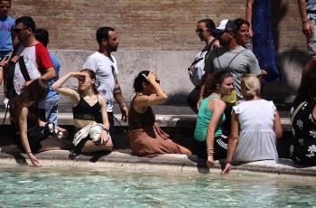 Transeúntes en Italia soportan la ola de calor.