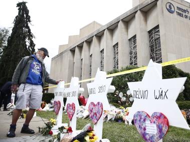 Vista de flores, velas y cartas depositadas frente a los monumentos de la Estrella de David con los nombres de las 11 personas que murieron en la sinagoga de la Congregación del Árbol de la Vida.