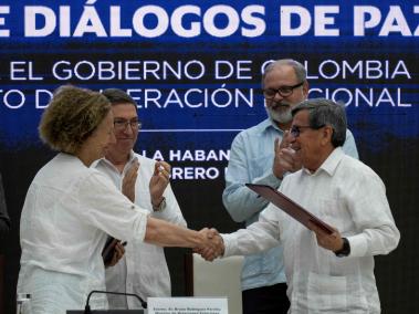 Vera Grabe (i), representante del gobierno, y Pablo Beltrán (d), del Eln, se dan la mano tras firmar la prórroga del cese el fuego en Cuba.