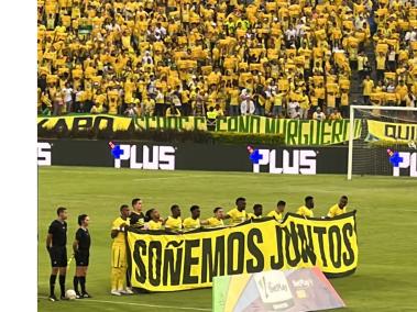 Los jugadores del Atlético Bucaramanga salieron al campo de juego en el partido contra Junior con una pancarta que decía "Soñemos juntos"