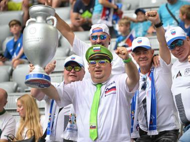 Hinchas de Eslovenia celebran con una réplica del trofeo de la Eurocopa.