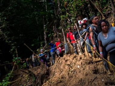 Migrantes descienden por un sendero pantanoso en el Tapón del Darién.