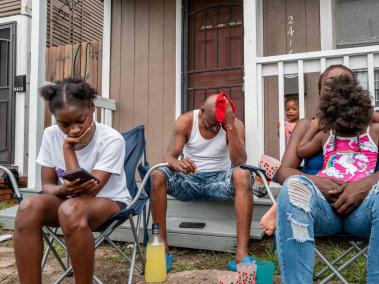 Una familia se sienta frente a su casa en Houston, Texas.
