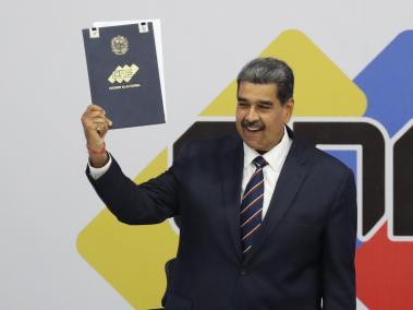 El presidente de Venezuela, Nicolás Maduro, sostiene el acta que lo proclama presidente reelecto por el Consejo Nacional Electoral (CNE) este lunes, en Caracas (Venezuela). Maduro denunció que está en marcha un intento de golpe de Estado "de carácter fascista", en vista de los cuestionamientos a su reelección -anunciada el domingo por el ente electoral-, que fue rechazada por la oposición mayoritaria y buena parte de la comunidad internacional.