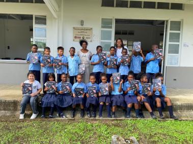 Nayely Waitotó (a la derecha), junto a un grupo de niños de la escuela Zoila Emilia Garcés de Pizarro y su profesora, Nelly Rivas, quienes sostienen una de las obras de la colección ‘Leer es Mi Cuento’.