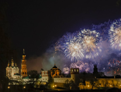 Sobre el Convento Novodevichy, también conocido como Monasterio Bogoroditse-Smolensky, en Moscú, iluminan los fuegos artificiales durante la conmemoración de el Día de la Victoria.