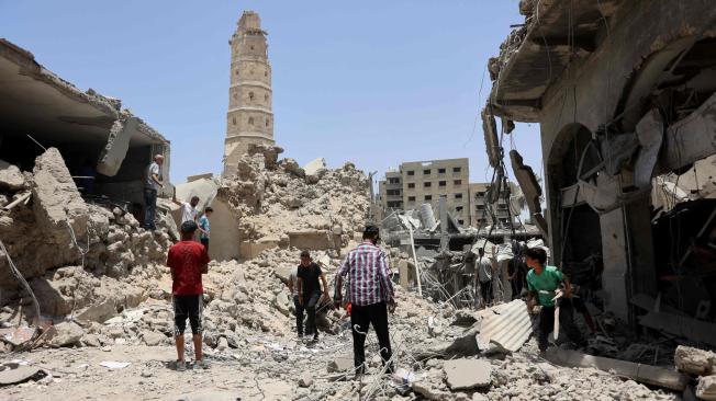Socorristas se encuentran entre los escombros de los edificios destruidos tras el bombardeo israelí cerca de la Gran Mezquita Omari en la Ciudad Vieja de Gaza.