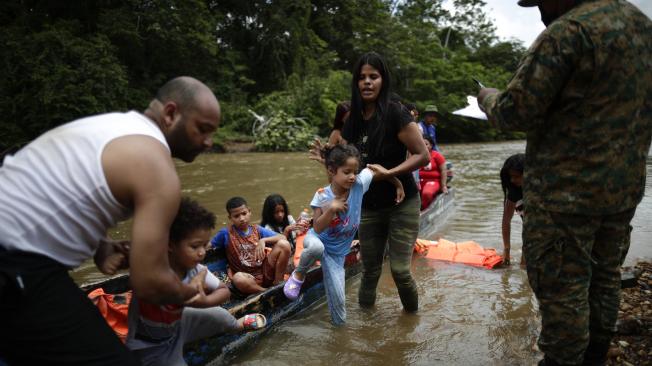 Migrantes bajan de canoas para ser trasladados a una estación de recepción migratoria en Lajas Blancas, Panamá, el 10 de junio de este año.