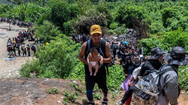 Un migrante va con su bebé por la selva del Darién, cerca de Bajo Chiquito, primer puerto fronterizo en Panamá.