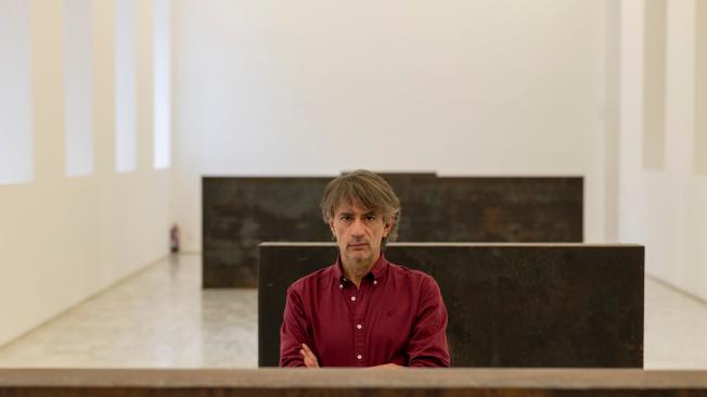 El escritor español Juan Tallón, en el Museo Reina Sofía, posa en la obra ‘Equal-Paralle / Guernica-Bengasi’, de Richard Serra. Esta misma obra fue la que desapareció misteriosamente en 2006.