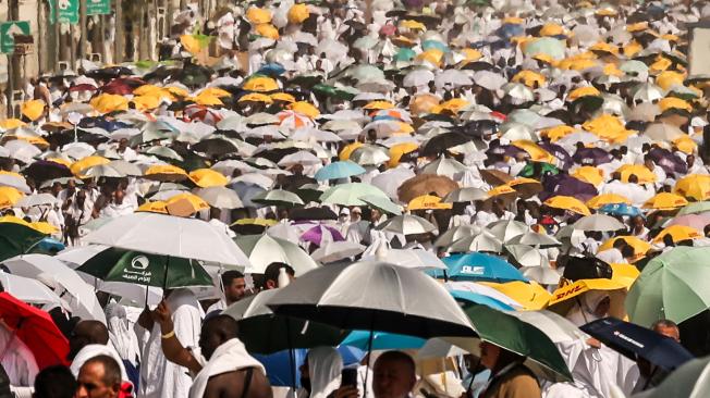 Peregrinos musulmanes usan paraguas para protegerse del sol cuando llegan a la base del Monte Arafat, también conocido como Jabal al-Rahma o Monte de la Misericordia, durante la peregrinación anual.