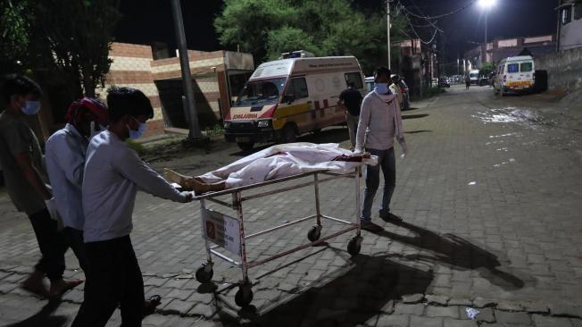 Transportan el cuerpo de una víctima de la estampida en India.