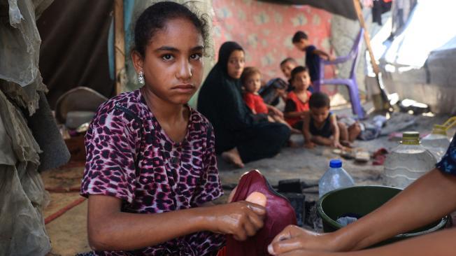 El 8 de julio de 2024, jóvenes lavaron a mano ropa con una barra de jabón en su tienda de desplazados en Deir el-Balah, en el centro de la Franja de Gaza.