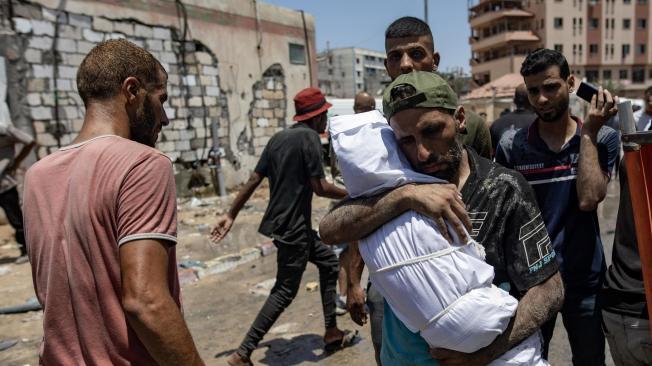 Un palestino lleva el cuerpo de su hijo muerto tras una incursión israelí en las tiendas de desplazados de la zona de Al-Mawasi, en Jan Yunis.