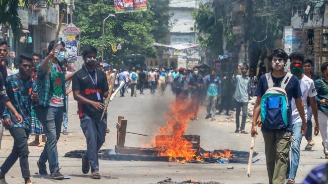 Los manifestantes encienden un fuego mientras se enfrentan con la policía, el Batallón de Acción Rápida (RAB) y miembros de la Liga Chhatra de Bangladesh (BCL) y la Liga Jubo, durante las protestas estudiantiles en curso bajo el lema 'Movimiento estudiantil contra la discriminación' en el área de Mirpur en Dhaka, Bangladesh.