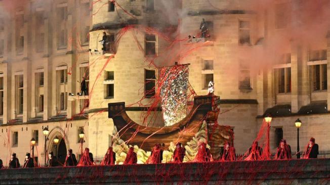 Figuras sin cabeza que representan a la reina María Antonieta del siglo XVIII actuaron a lo largo de un dique del río Sena, frente a la Conciergerie, donde la reina estuvo cautiva durante la Revolución Francesa.