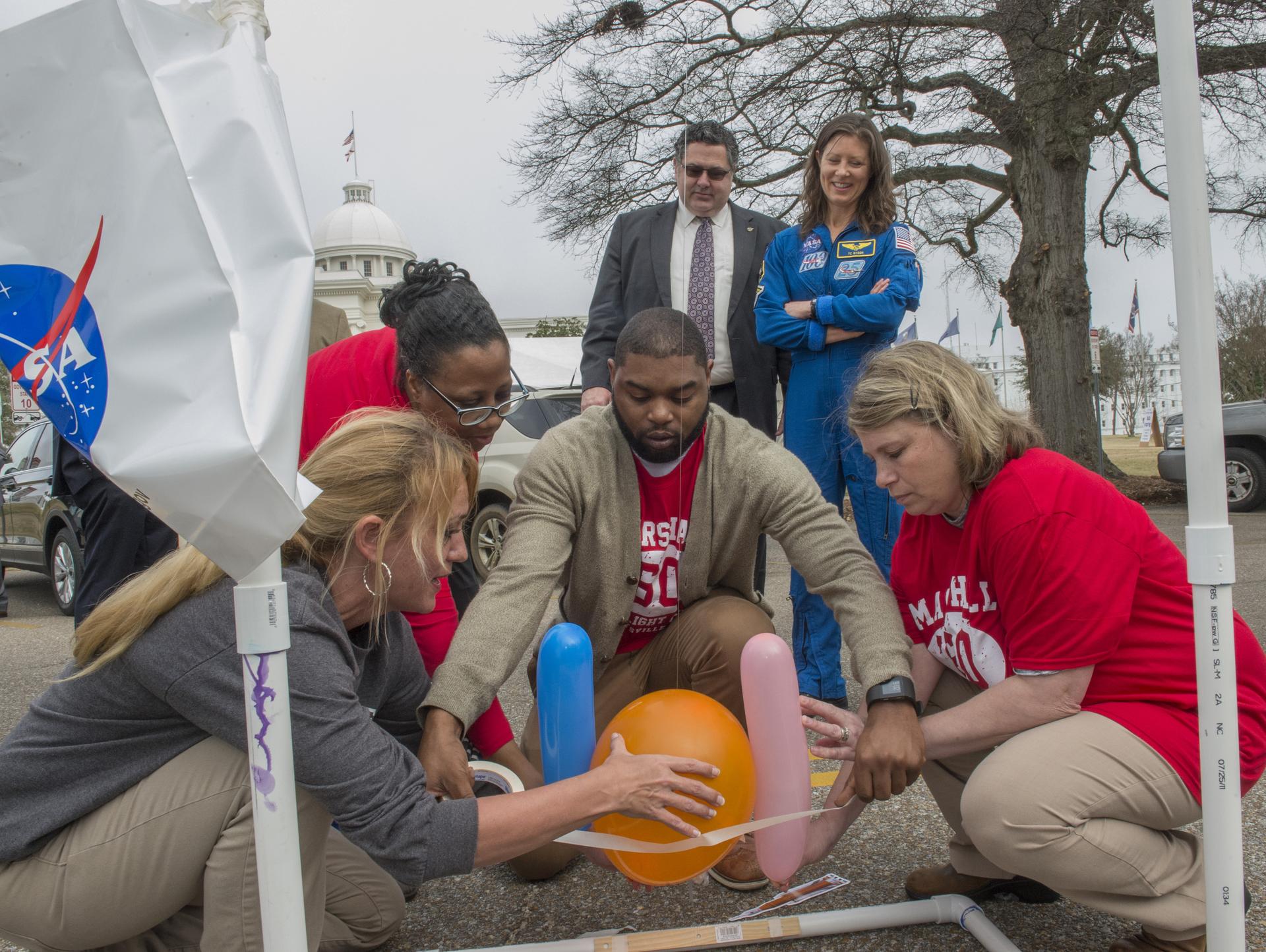 A group of educators working on a balloon rocket activity