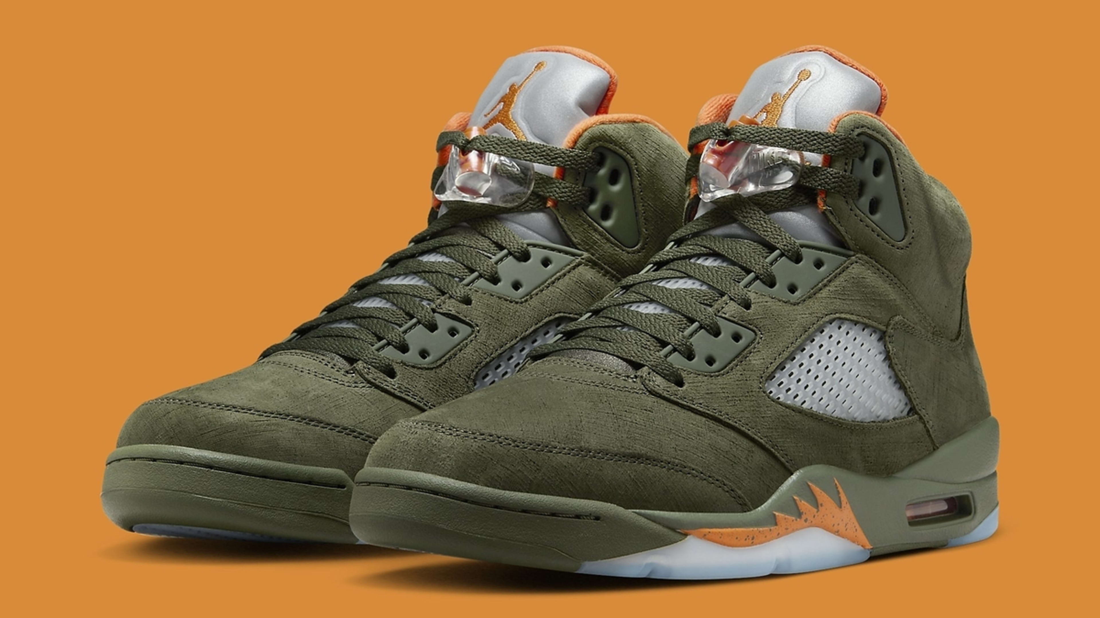 Pair of green high-top sneakers against an orange background