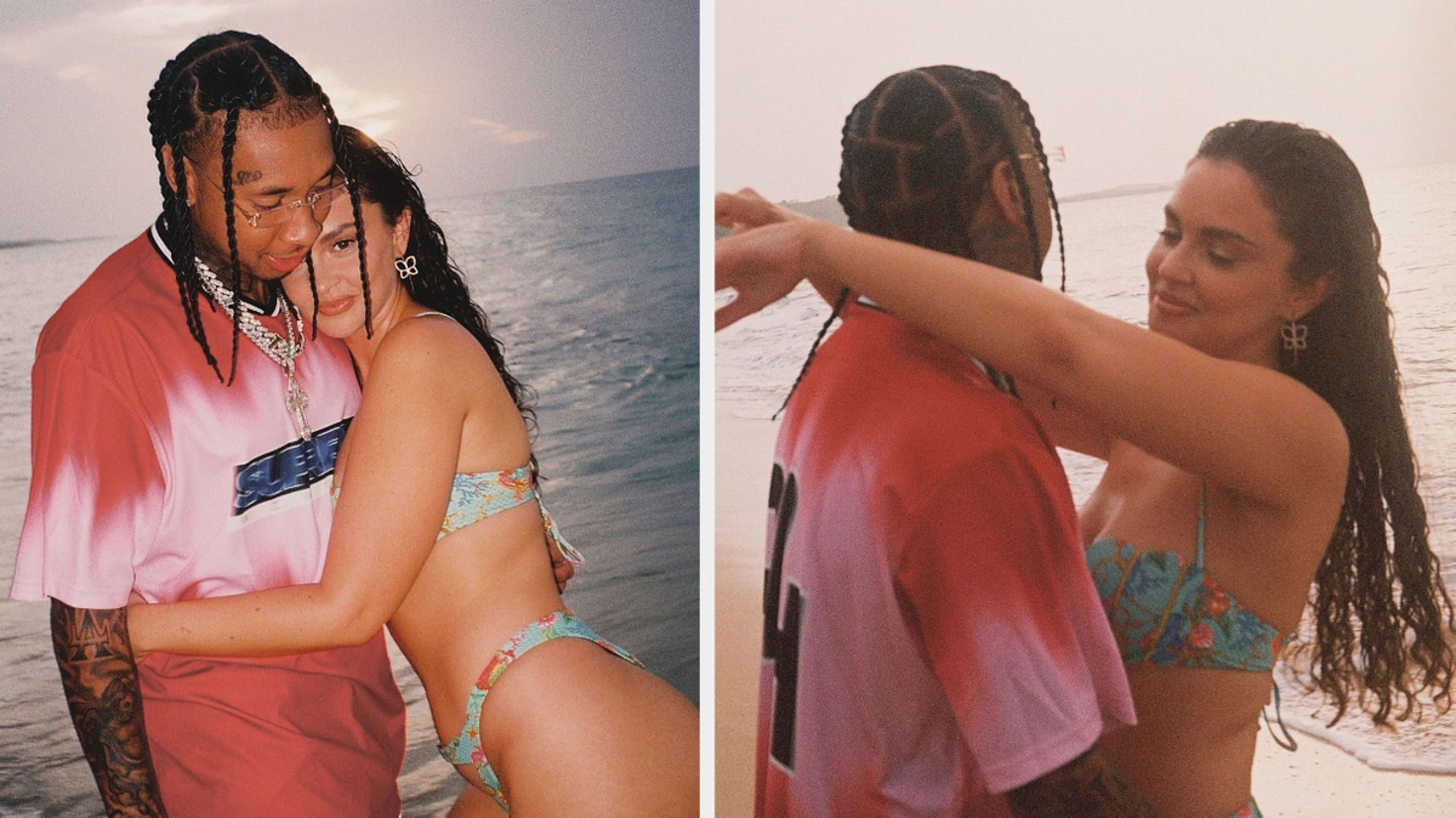 Tyga and Sabrina Claudio embrace on a beach in sunset, with Sabrina in a patterned bikini and Tyga in a casual graphic shirt