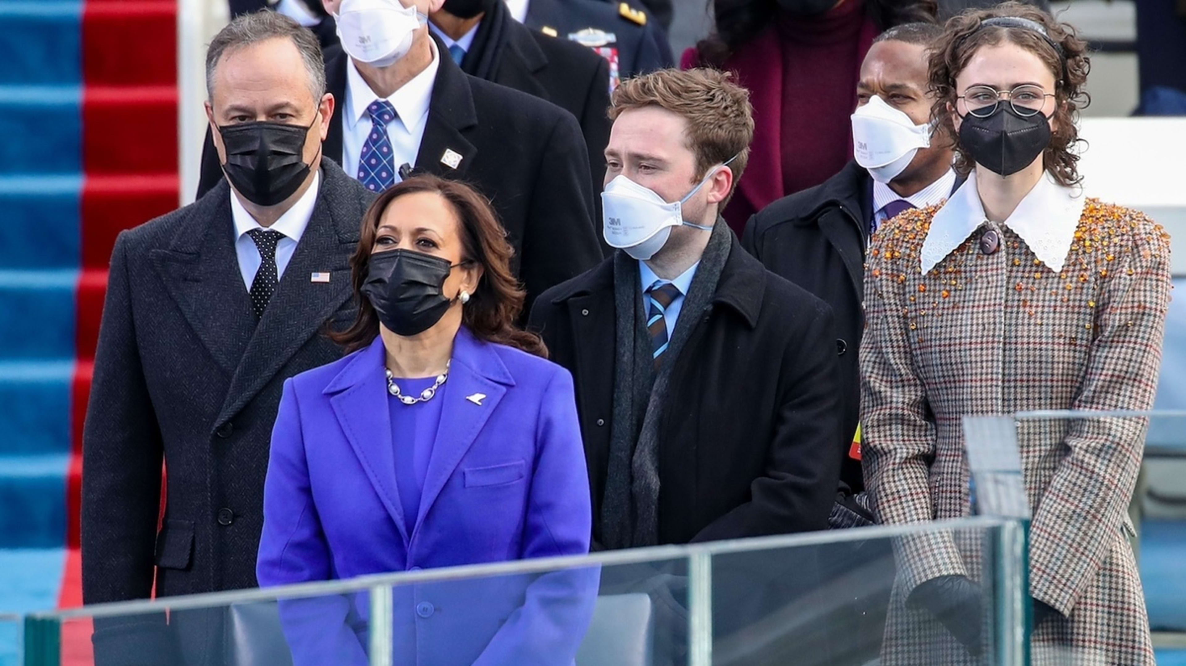 Doug Emhoff, Kamala Harris, Cole Emhoff, and Ella Emhoff stand together at an official event, all wearing formal attire and protective face masks