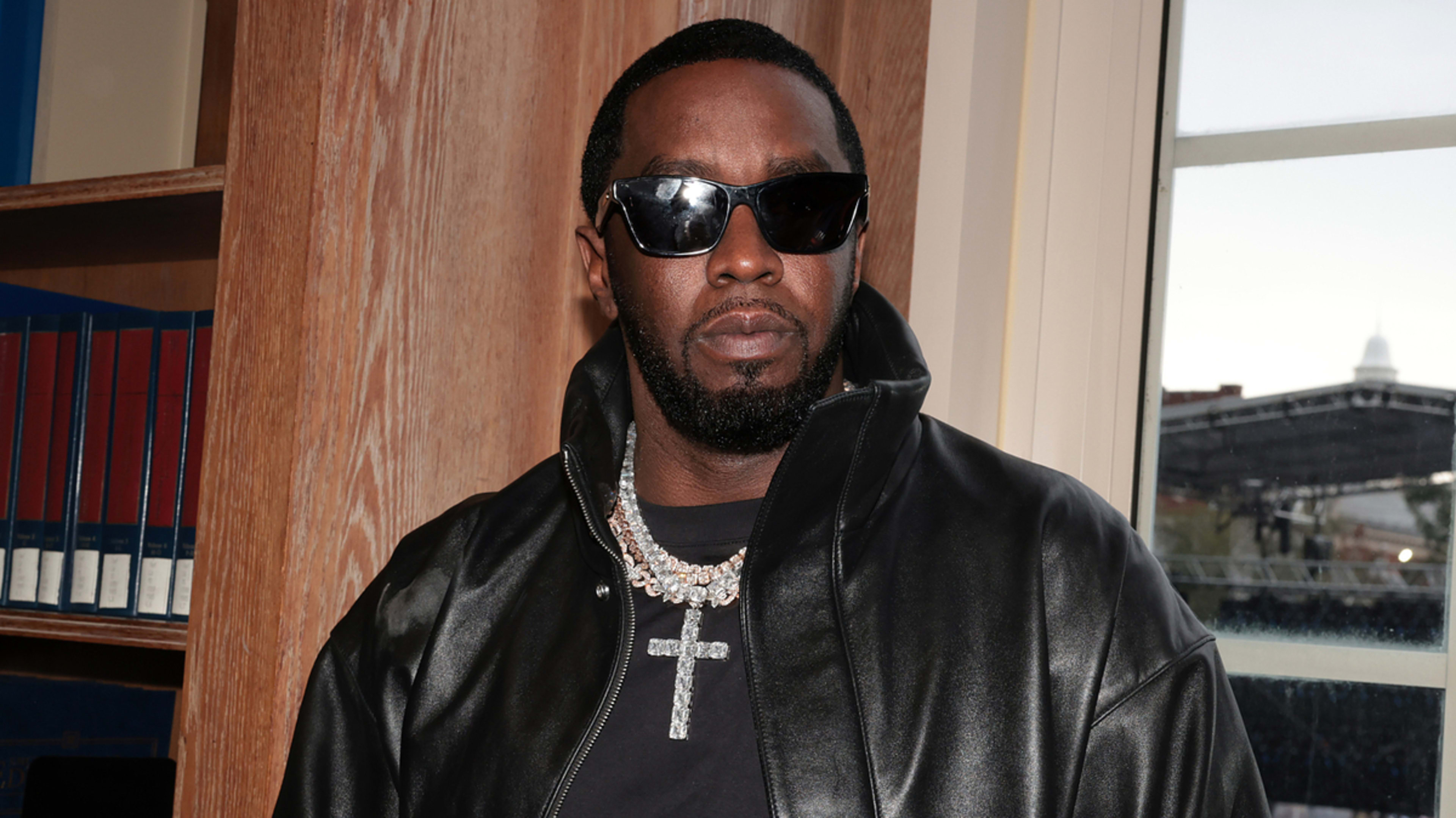 Sean "Diddy" Combs, wearing a black leather jacket and sunglasses, attends a music event