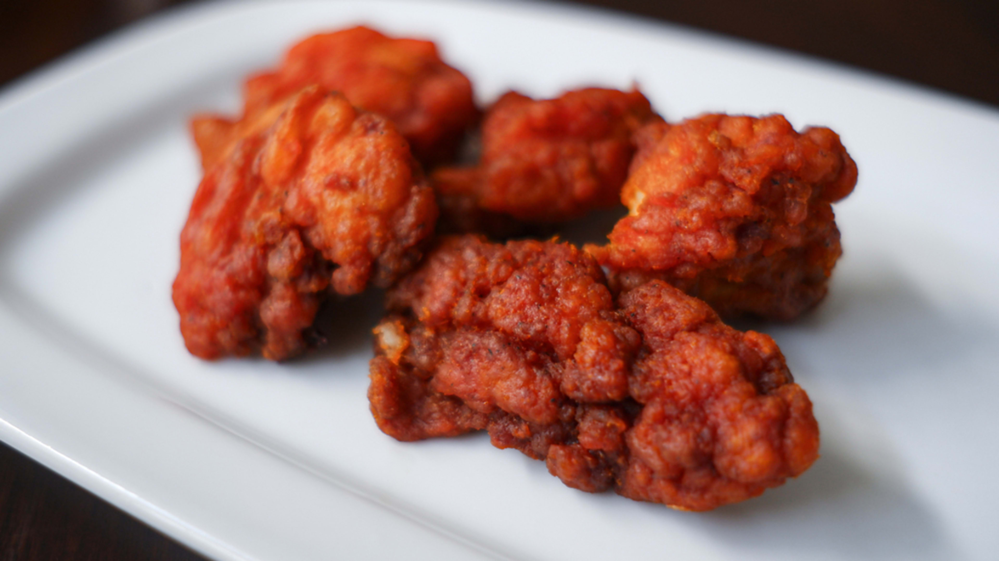 Boneless buffalo chicken wings on a white rectangular plate