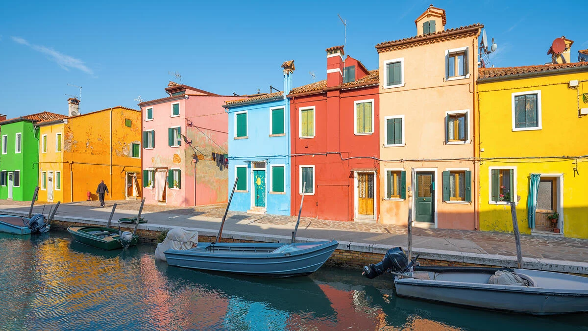 Colorful buildings line a waterfront with boats floating by the dock