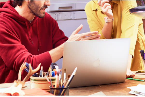 two people talking in front of a computer