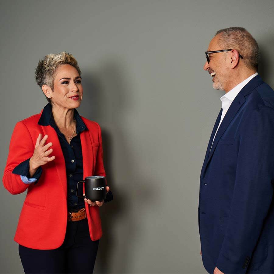 two coworkers standing together talking 