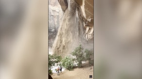 Climber rappels next to raging muddy waterfall sparked by flash floods in Utah