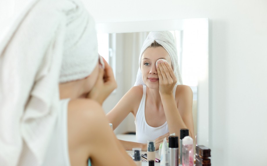 Pretty young woman is cleaning her face