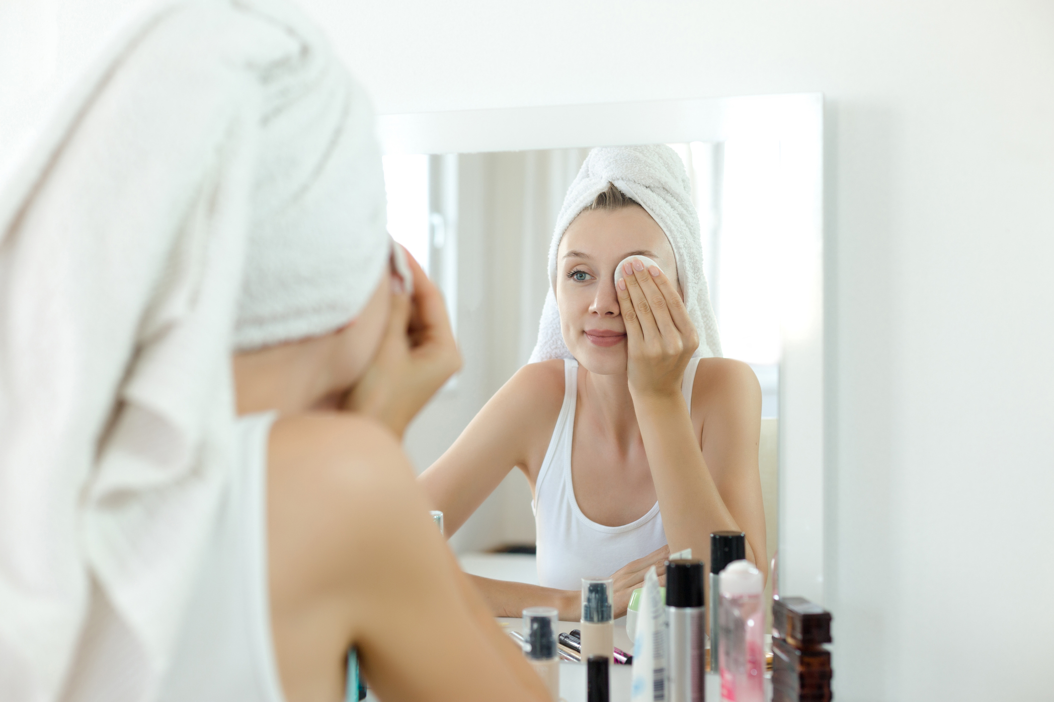 Pretty young woman is cleaning her face