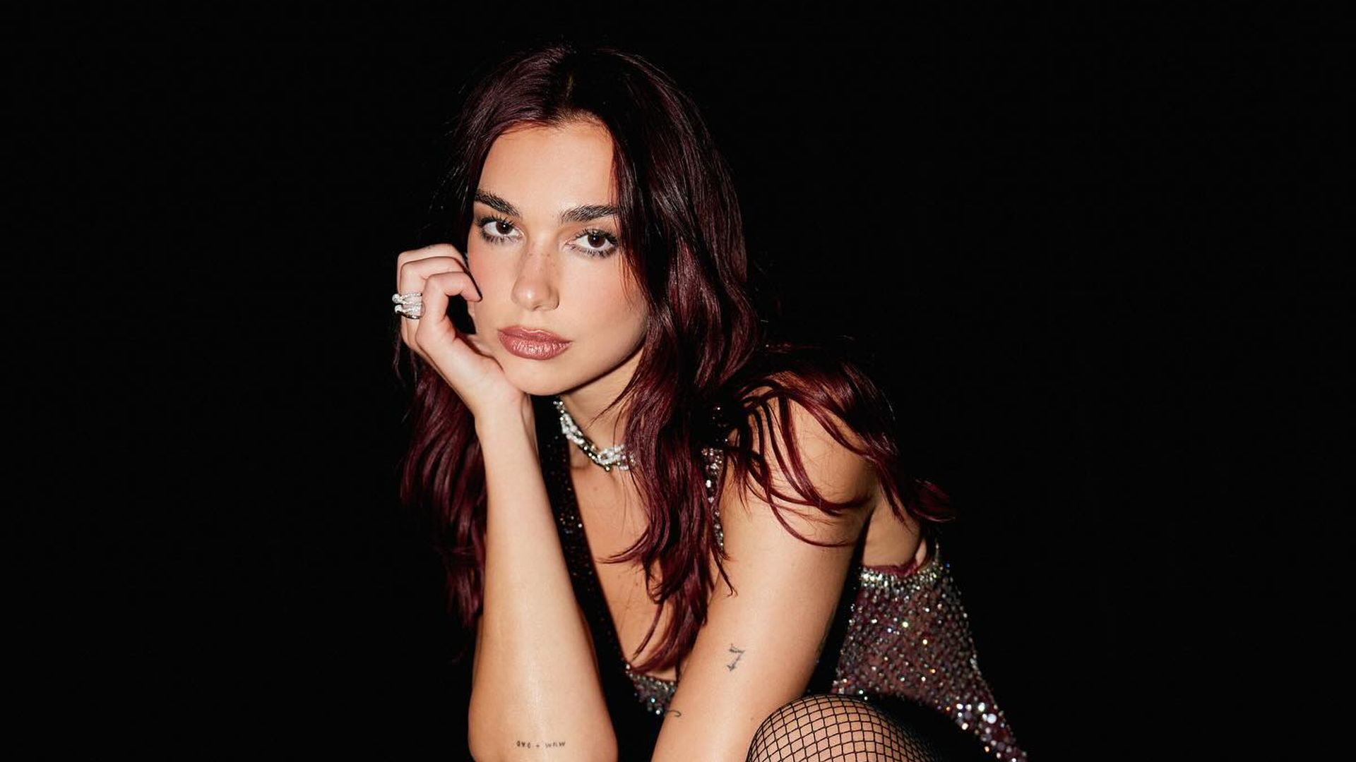 Dua Lipa just paired fishnet tights with white leather hot pants and it's a major Saturday night mood