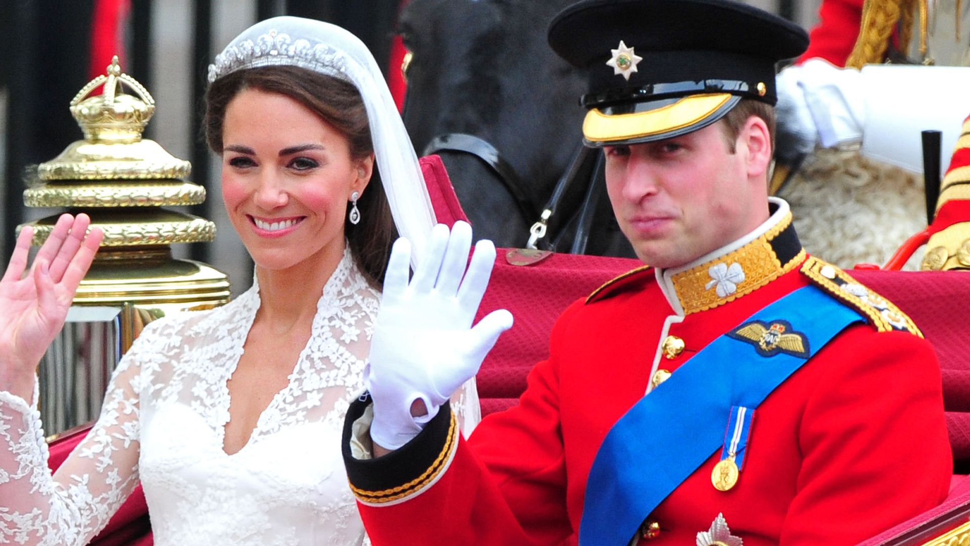 Prince William and Princess Catherine waving in their wedding carriage