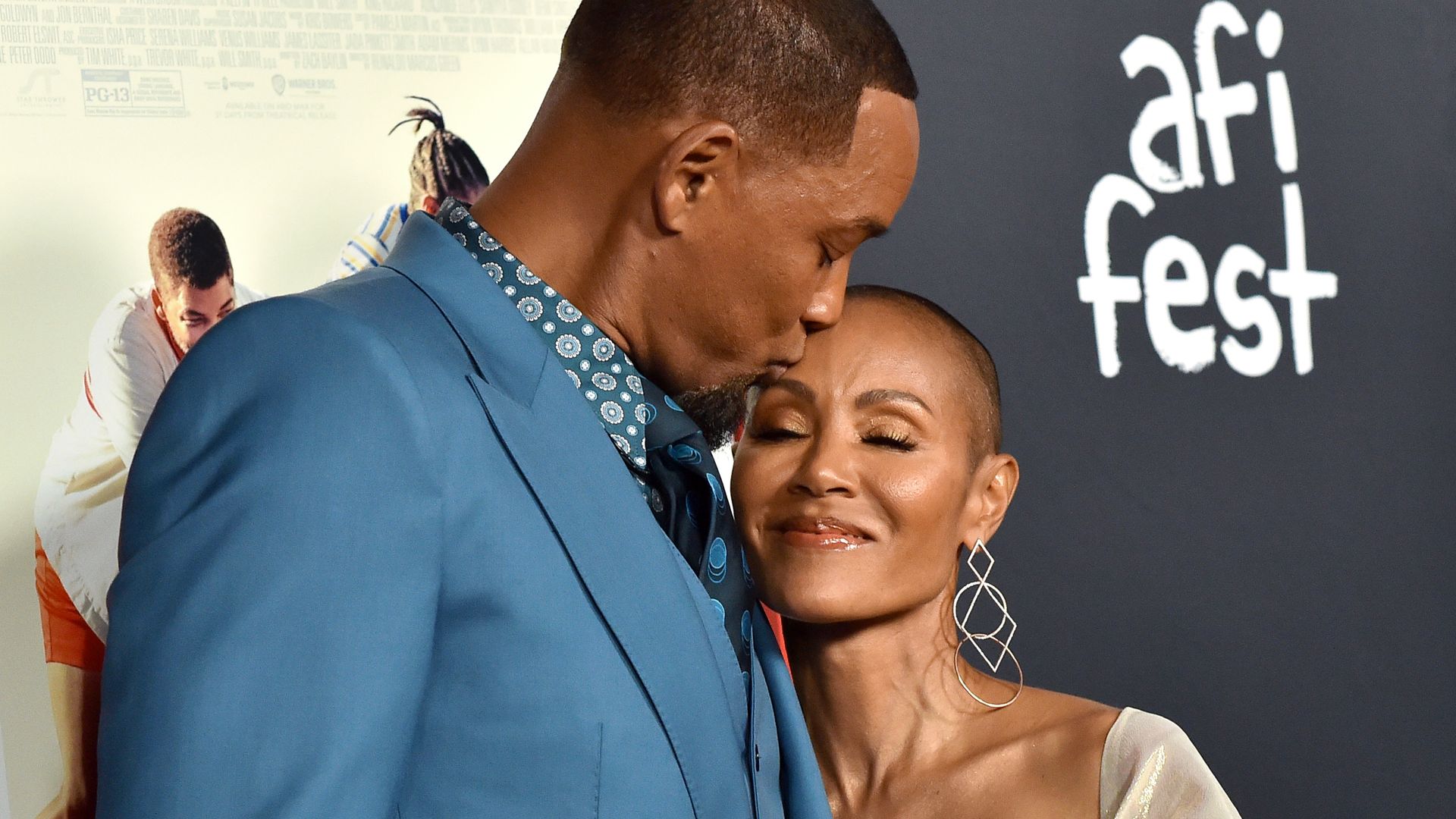 Jada Pinkett Smith and Will Smith cradling each other lovingly while stood for a red carpet photo