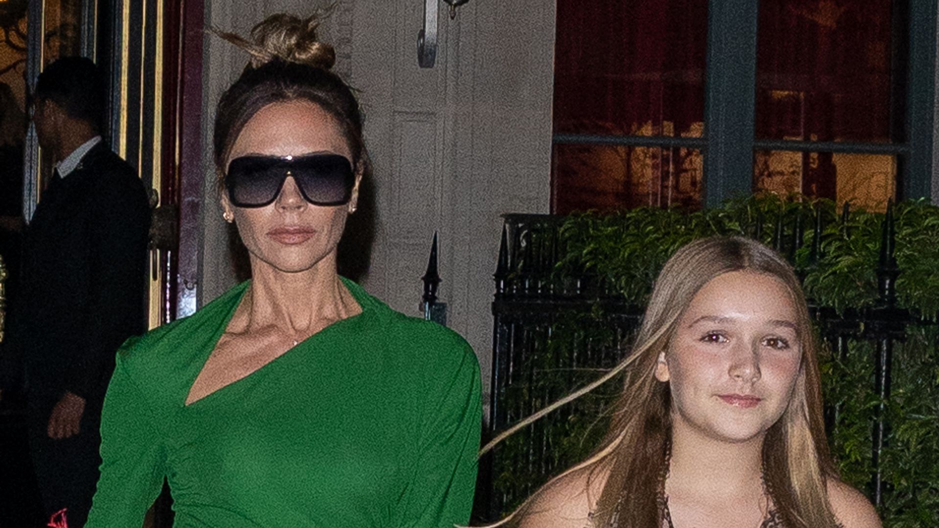 Victoria Beckham in a green dress and Harper Beckham in a yellow dress