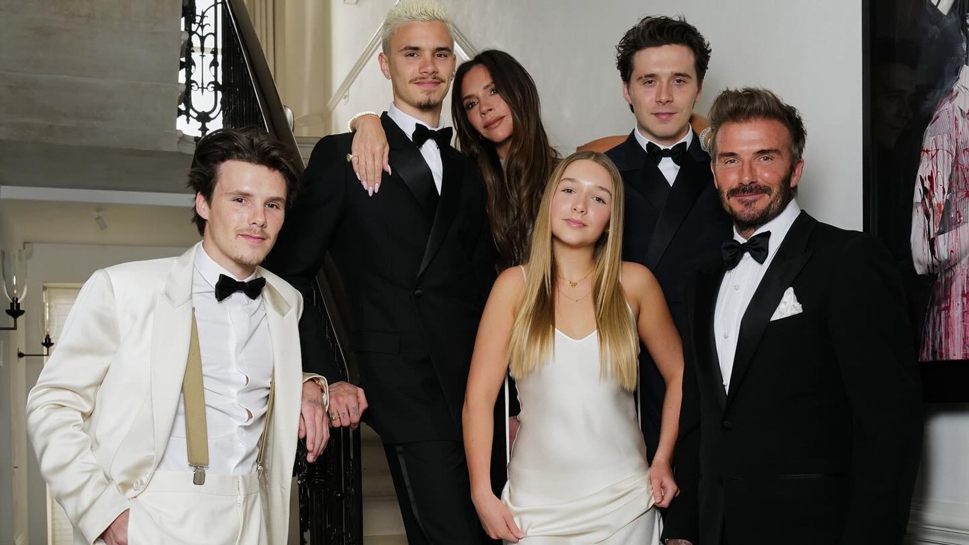 Harper Beckham wearing a white dress with the Beckham family