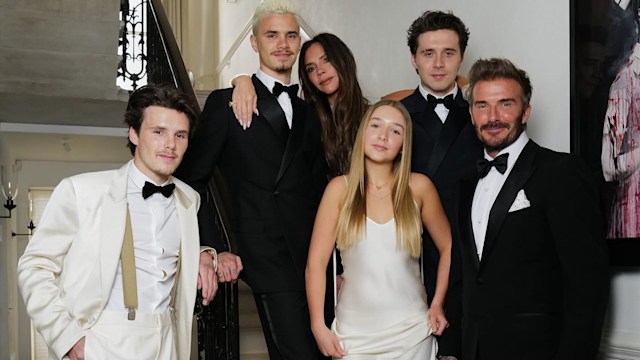 Harper Beckham wearing a white dress with the Beckham family