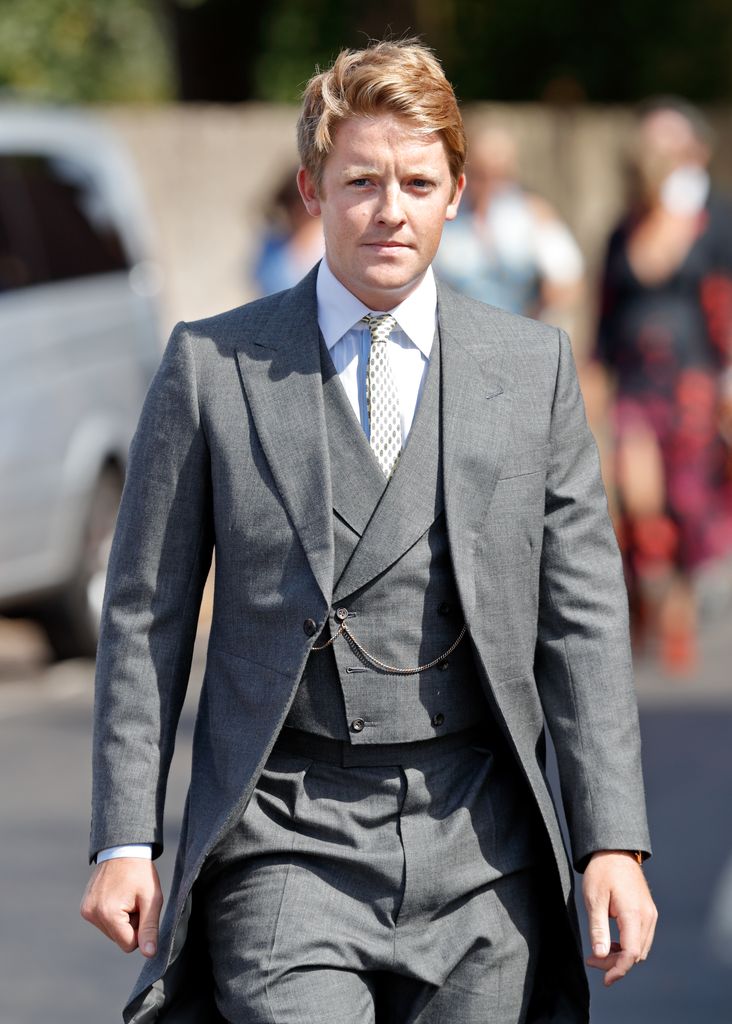 Hugh Grosvenor, Prince George's godfather, in a grey three-piece suit in the sunshine