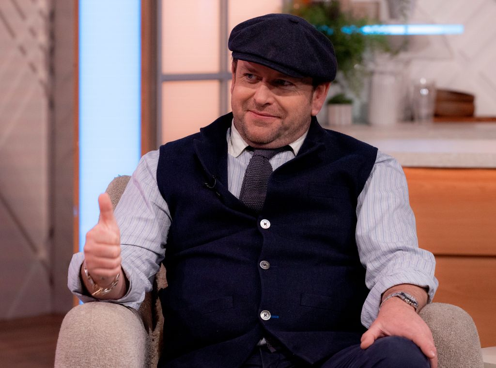 man wearing waistcoat and flat cap 