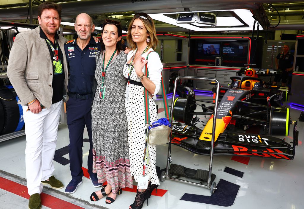 James Martin in white trousers and a black top posing for a photo with Louise in a white dress at the F1