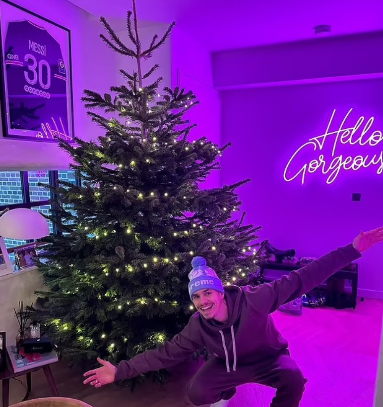 Romeo Beckham in front of a christmas tree