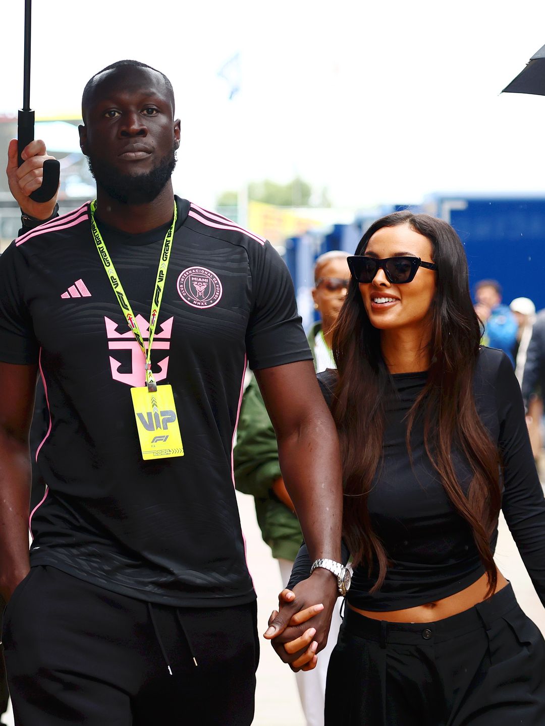 Stormzy and Maya Jama walk in the Paddock after practice ahead of the F1 Grand Prix of Great Britain at Silverstone Circuit on July 05, 2024 in Northampton, England. (Photo by Bryn Lennon - Formula 1/Formula 1 via Getty Images)