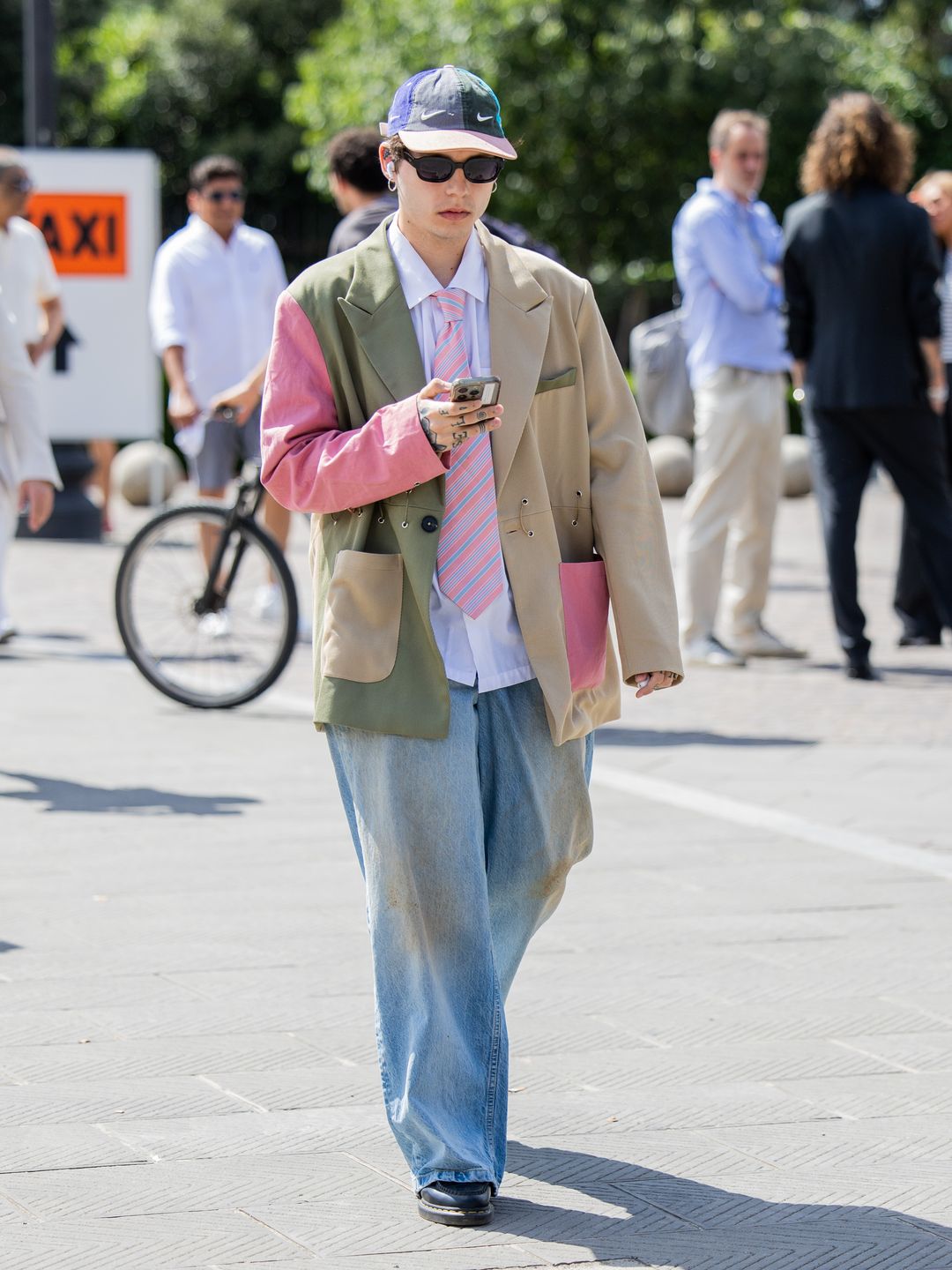 A guest wears oversized mixed colored blazer, wide leg denim jeans during Pitti Immagine Uomo 106