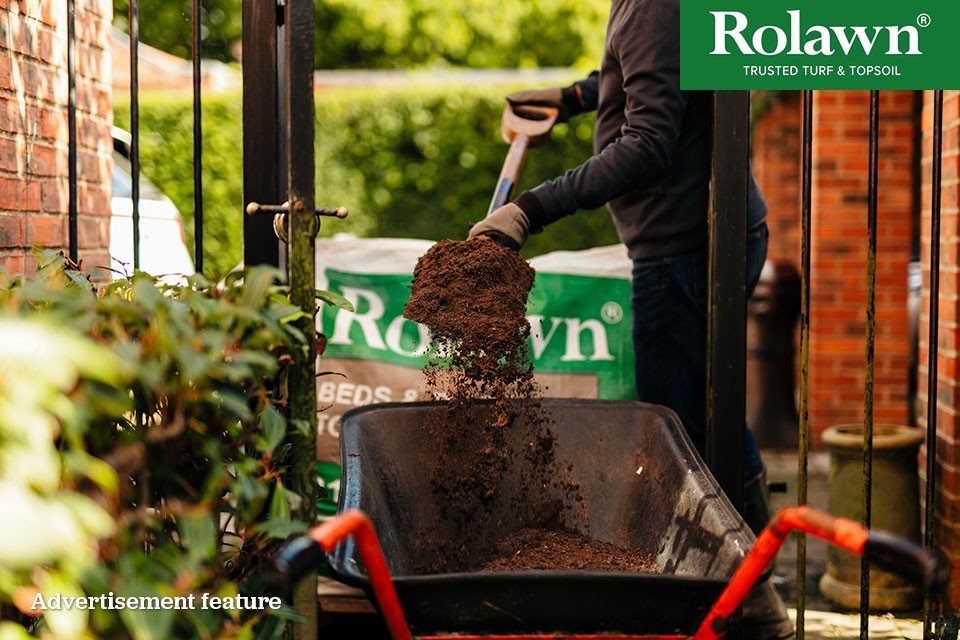 Rolawn logo | Someone using a spade to move topsoil into a wheelbarrow