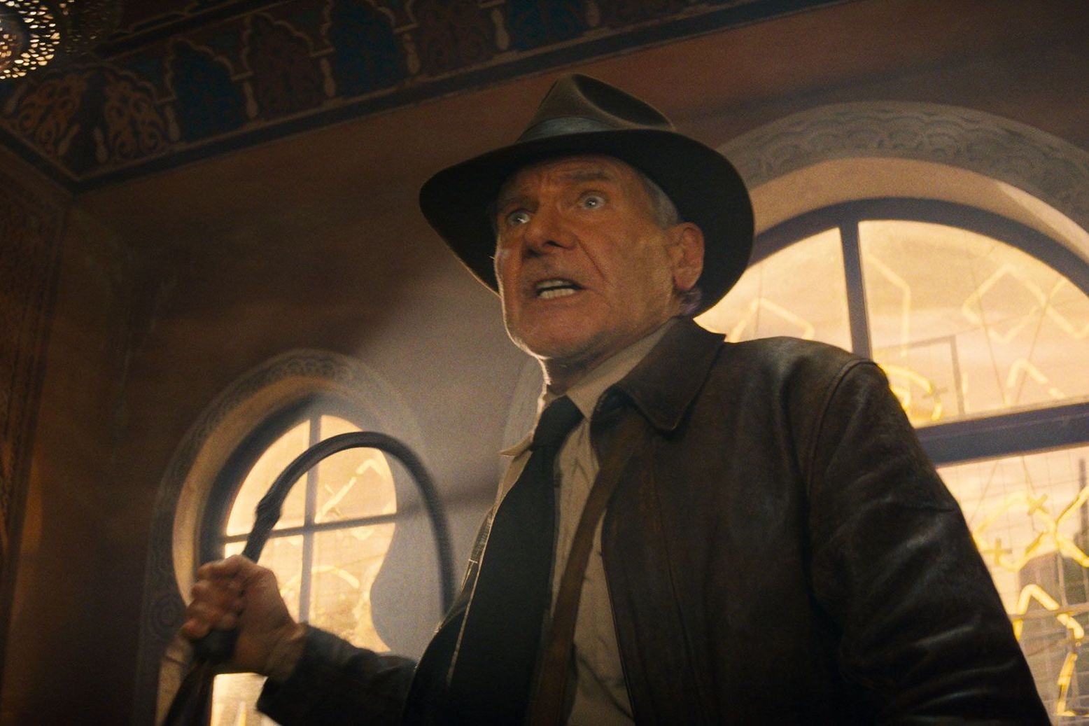 Harrison Ford as Indiana Jones in Indiana Jones and the Dial of Destiny, holding a whip and looking angry