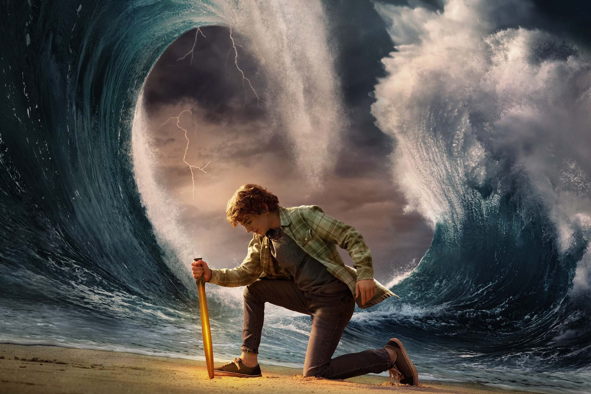 Percy Jackson kneels down and holds a glowing sword to the ground as giant ocean waves rise behind him