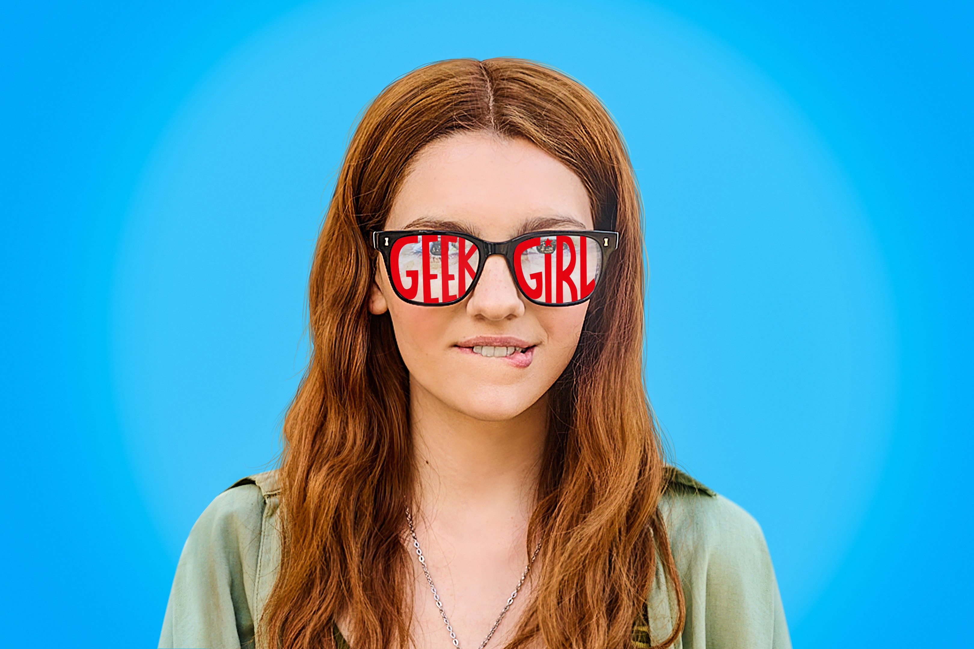 Emily Carey as Harriet Manners in Geek Girl. She is stood against a blue background and has sunglasses on which say the title, Geek Girl