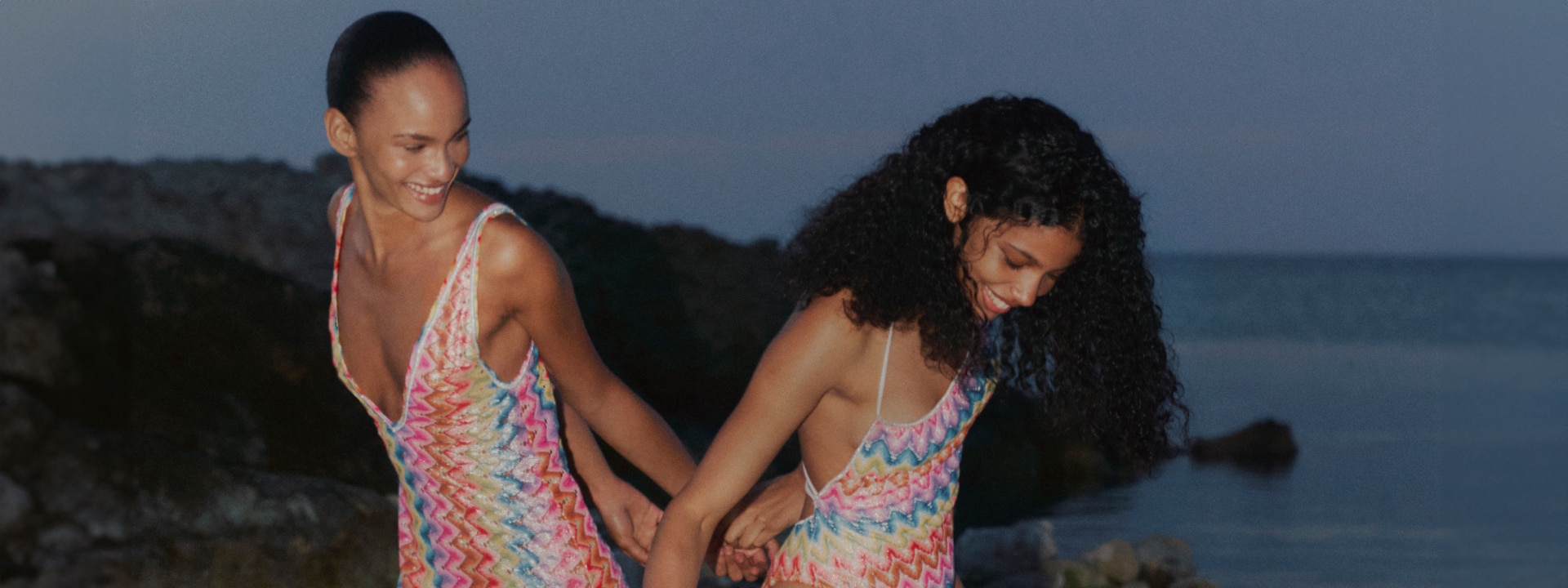 Two models are wearing a multicolour cover-up and a swimsuit from the new Beachwear collection