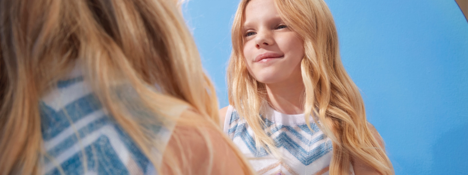 A little girl is wearing a zig zag dress